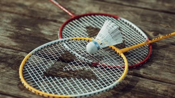 Badminton rackets and a birdie on a wood table
