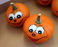 Two pumpkins with silly painted faces.