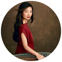 photo of Bei Bei with hand placed on guzheng (Chinese zither)